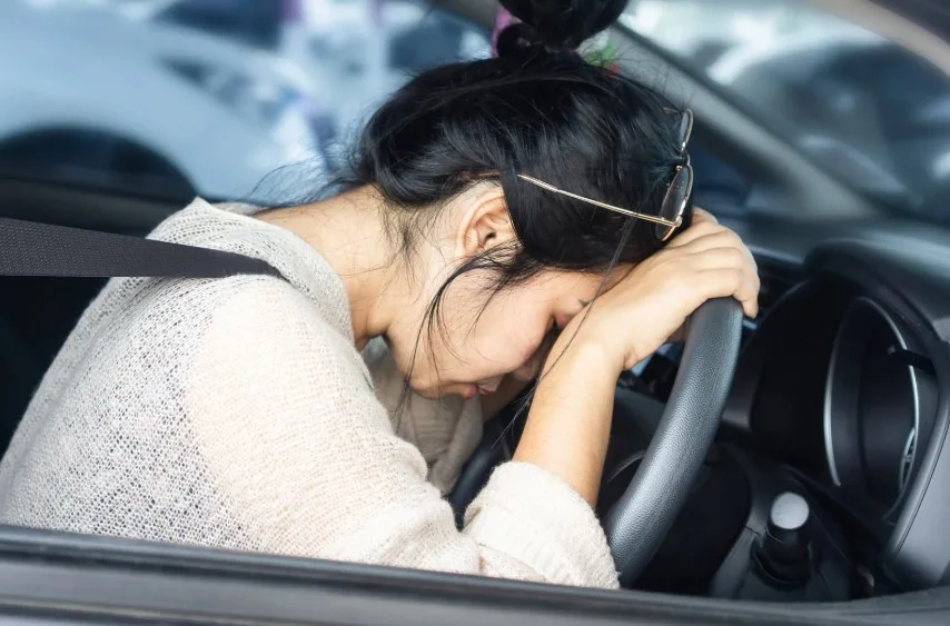 Frustrated driver resting head on steering wheel after experiencing 2022 Ram 1500 problems that may qualify for lemon law