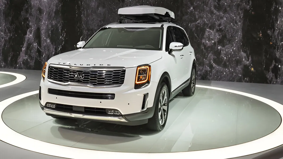 White 2020 Kia Telluride with roof cargo box on display at auto show highlighting a model known for 2020 Kia Telluride problems