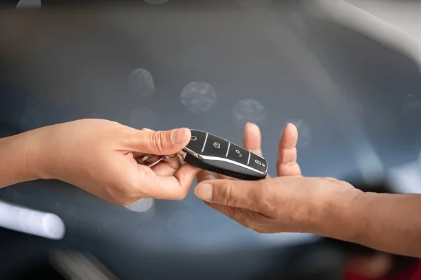Handing over car keys representing Lemon Law buyback and replacement warranty process.