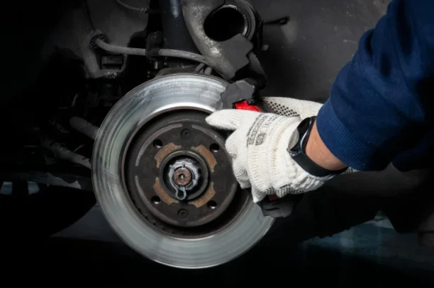 Mechanic checking faulty brake system, a common issue in lemon law vehicle claims, 247lemonlaw
