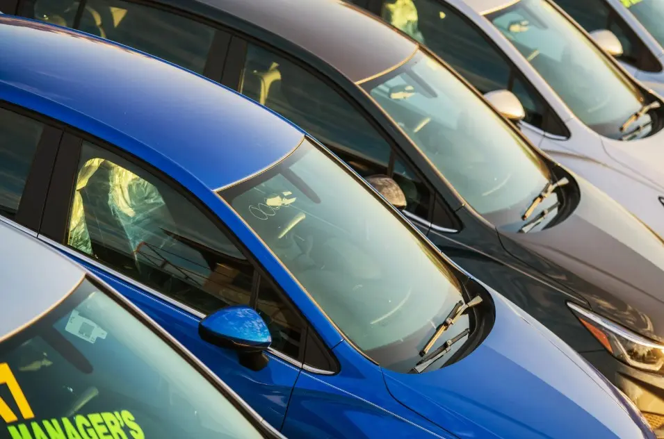 Row of new and used vehicles at a dealership, highlighting potential lemon cars under warranty