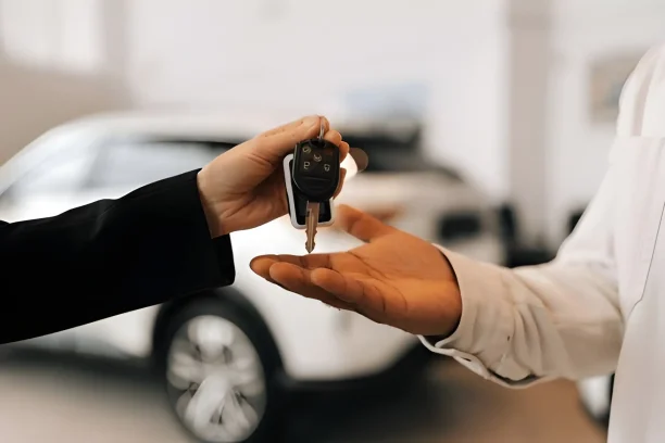 Customer receiving car keys at dealership, representing new vehicle purchase and Lemon Law warranty coverage.