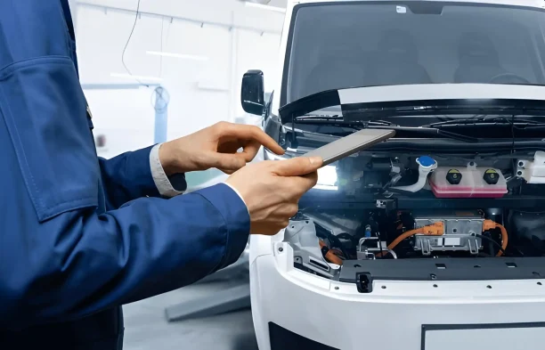 Mechanic inspecting an electric vehicle system which may reveal recurring defects eligible for Lemon Law protection.