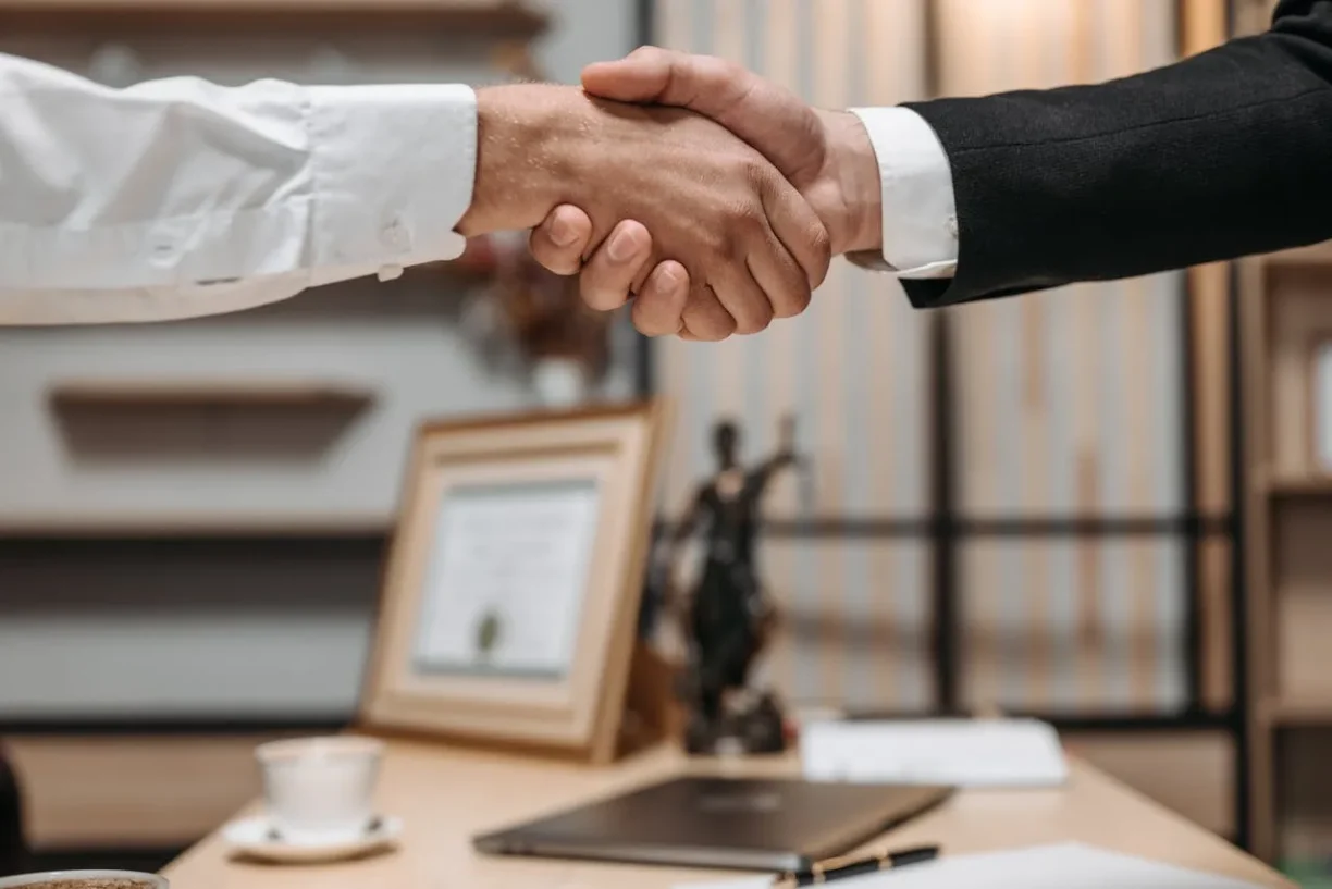 Client and attorney handshake after resolving a Lemon Law vehicle dispute