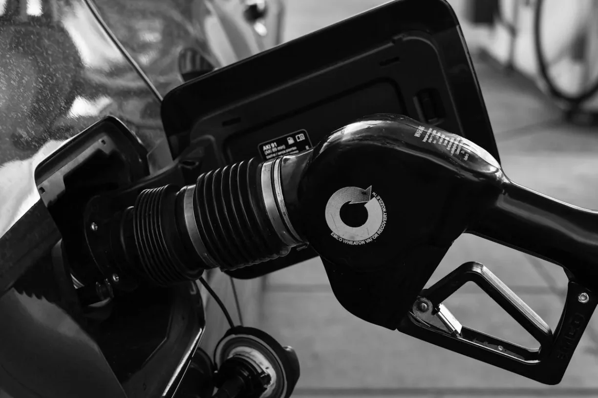 Close-up of a fuel pump nozzle inserted into a vehicle’s gas tank during refueling