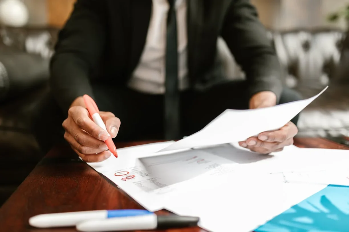 Person reviewing and signing legal documents at a desk
