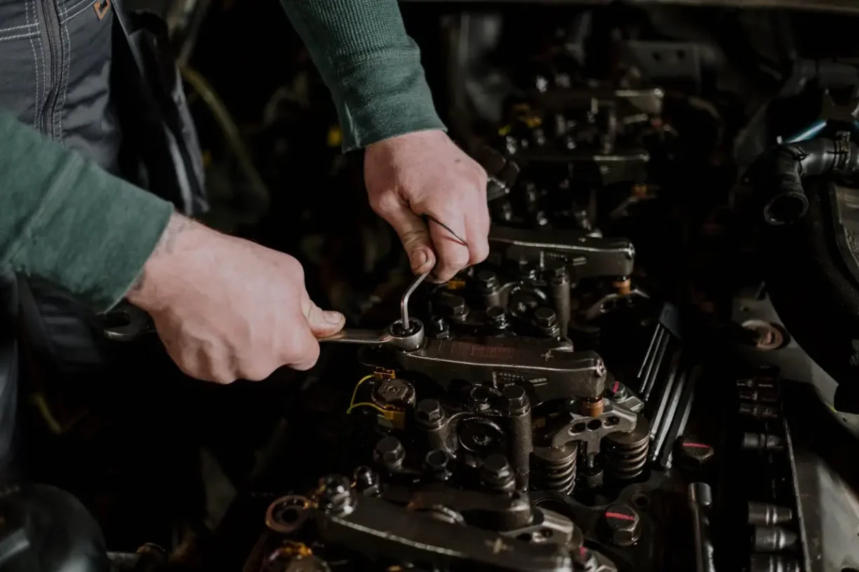 Auto mechanic tightening engine components during repair