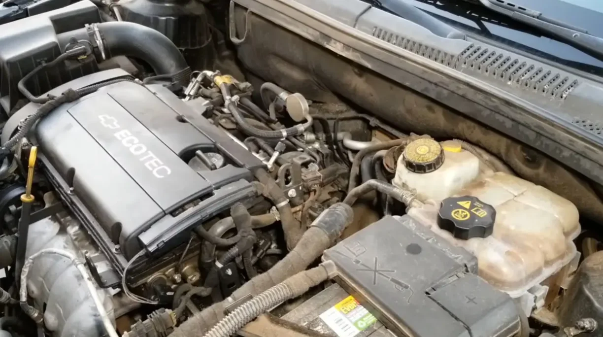 Car engine bay showing mechanical components and wiring