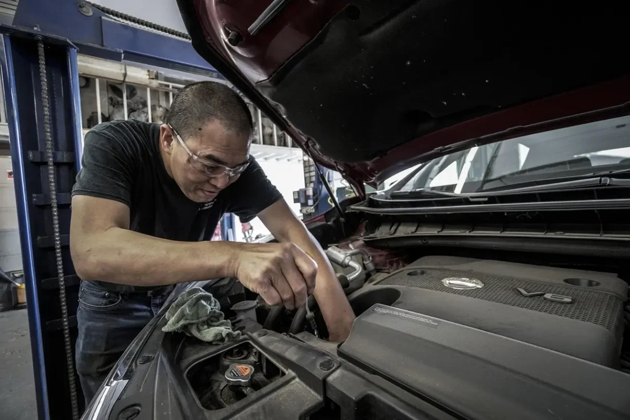 Professional mechanic inspecting the engine of a 2021 Jeep Compass Trailhawk to document persistent mechanical defects for a lemon law claim.